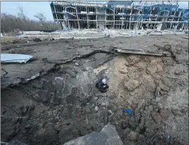  ?? GETTY IMAGES — FOR TRIBUNE NEWS SERVICE ?? A communal worker sits in a crater after Russian missiles struck in Kharkiv, Ukraine, on Saturday. At least 11 were killed in Ukraine and 11 hurt from Russian strikes.