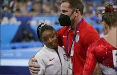  ?? Associated Press ?? Simone Biles receives a hug from coach Laurent Landi after she exited the team gymnastics final Tuesday in Tokyo, a move that opened a days-long dialogue on the mental toll sports can take on elite athletes.