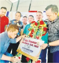  ?? ?? RASMI: Masiung (depan) menurunkan tandatanga­n sebagai simbolik perasmian Dewan Kampung Talibu Tongod.