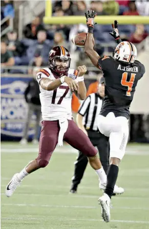  ?? AP Photo/John Raoux ?? Oklahoma State cornerback A.J. Green (4) knocks down a pass thrown by Virginia Tech quarterbac­k Josh Jackson (17) during the first half of the Camping World Bowl on Thursday in Orlando, Fla.