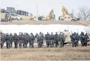  ?? REUTERS ?? Law enforcemen­t officers advance into the main opposition camp against the Dakota Access oil pipeline on Thursday.