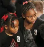  ?? JACQUelyN MARtiN
— AP ?? Malana Pinckney, left, and eliana Pinckney, wearing pins with a photo of their father, slain South Carolina Sen. Clementa Pinckney, arrive in the east Room of the White House in Washington, tuesday.