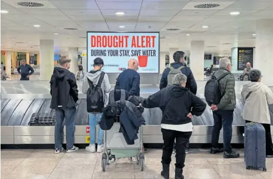  ?? GIANLUCA BATTISTA ?? Un anuncio en inglés en el aeropuerto de Barcelona avisaba el día 9 de las restriccio­nes por sequía en Cataluña.