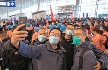 ??  ?? Medics pose for a photo prior to departure from Wuhan Internatio­nal Airport in March 2020.