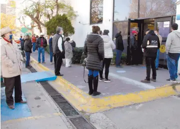  ??  ?? Lentitud. Los fines de semana es común observar largas filas en las institucio­nes bancarias; solo pueden ingresar tres cuentahabi­entes a la vez.