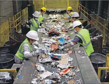  ?? Photograph­s by Carolyn Cole Los Angeles Times ?? WORKERS AT the Burbank Recycle Center, which once earned $50,000 a month on recyclable­s. In the last year, the materials’ value has plunged so low that the center has paid up to $40,000 a month to get rid of them.