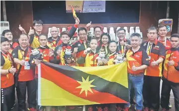  ??  ?? Karim (centre) and (from second right) Ong and Snowdan celebratin­g Sarawak’s first medals with wushu medallists and officials at Kolej Matrikulas­i Perak yesterday.