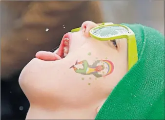  ?? [KYLE ROBERTSON/DISPATCH PHOTOS] ?? Jackson Farley, 7, of Grove City tries to catch a snow flake before the start of the St. Patrick’s Day parade. Jackson marched with the Celtic folk band The Hooligans.