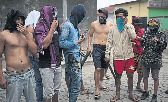  ?? (/AP) ?? Armas caseras. Manifestan­tes encapuchad­os salen a las calles de Managua, la capital de Nicaragua, para enfrentar a fuerzas policiales y paramilita­res.