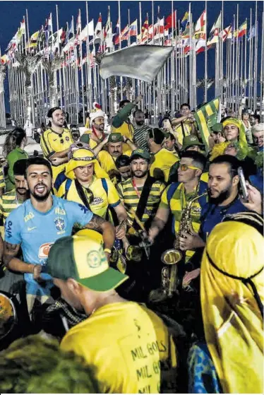  ?? Nelson Almeida / AFP ?? Hinchas con camisetas y banderas de Brasil en Doha, ayer.