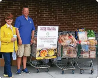  ??  ?? Newtown Rotarians Michele Knobloch and Dan Peterson with three cartloads of food bound for the needy at the Penndel Food Pantry, a service of the Bucks County Housing Group.