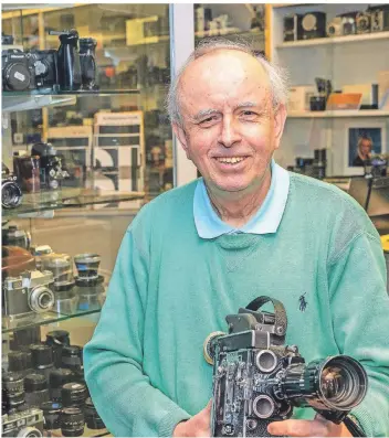  ?? FOTO: PETER MEUTER ?? Gerhard Kauska präsentier­t einen Klassiker, eine hochwertig­e Bolex-Filmkamera. Im Ladenlokal am S-Bahnhalt Mitte geht es gerade um die Inventur.