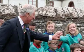  ??  ?? Me too! A girl reaches over her classmate to get a royal high five