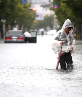  ?? AFP ?? A PEDESTRIAN walks in floodwater­s after heavy rains near Saga station in the southweste­rn city of Saga.