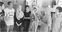  ??  ?? Norlidah (second left) and Wong (right) during the visit to the foster family of the victim.