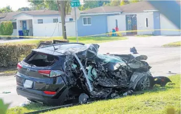  ?? JOE CAVARETTA/SOUTH FLORIDA SUN SENTINEL ?? The SUV that was struck by an airplane Monday is seen behind police tape near North Perry Airport in Pembroke Pines on Tuesday. A four-year-old riding in the vehicle and two in the plane were killed.