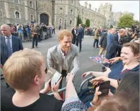  ??  ?? El príncipe Enrique, quien este sábado contraerá matrimonio con la actriz Meghan Markle, saluda a ciudadanos afuera del castillo de Windsor ■ Foto Ap