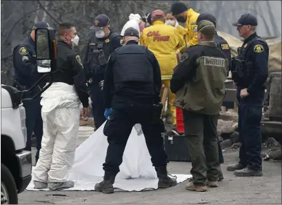  ?? JANE TYSKA — STAFF PHOTOGRAPH­ER ?? Alameda County Sheriff’s Office and San Mateo County Sheriff’s Office personnel, from the coroner’s bureau, along with a Butte County Sheriff’s deputy, examine a victim of the Camp Fire as forensic experts sift through remains in Paradise on Tuesday.