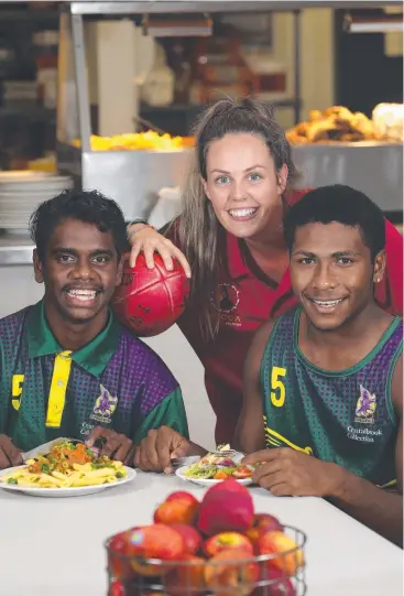  ??  ?? TUCK IN: Project co-ordinator Shelby Grant (centre) with Shannon Shaun, 14, and Meun Lifu-Nona, 15.