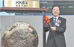  ??  ?? China Tower Corporatio­n Limited chairman of the Board, executive director and general manager Tong Jilu poses after striking a gong at the company’s IPO launch in Hong Kong on August 8. — AFP photo