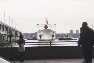  ?? Stephanie Keith / Getty Images ?? The USNS Comfort hospital ship pulls in to Pier 90 on the Hudson RIver on Monday in New York City. The Comfort, a floating hospital in the form of a Navy ship, is equipped to take in patients within 24 hours but will not be treating people with COVID-19. The ship's 1,000 beds and 12 operation rooms will help ease the pressure on New York hospitals, many of which are overwhelme­d with COVID-19 patients .