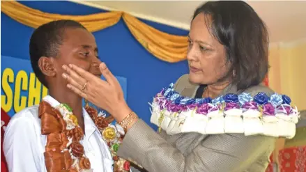  ?? Photo: Arieta Vakasukawa­qa ?? The Minister for Health and Medical Services, Rosy Akbar, wipes Simione Nadolo's tears after he was inducted headboy of Sabeto Central School in Nadi on February 1, 2018.