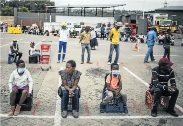  ?? Picture: Marco Longari/AFP ?? Shoppers wait in line at a supermarke­t in Soweto.