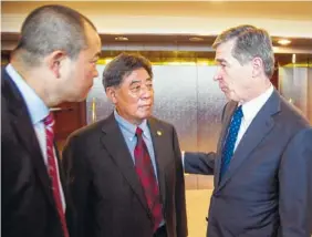  ?? THE ASSOCIATED PRESS ?? North Carolina Gov. Roy Cooper, right, speaks to Triangle Tire Chairman Ding Yuhua, center, and his translator Tuesday at Edgecombe Community College in Tarboro, N.C., after the company announced plans to build a tire plant that would eventually employ...