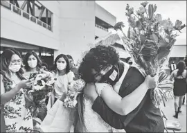  ??  ?? JESUS MEDINA hugs classmate Jade Magallanes at a Sierra Vista High awards banquet. The two are neighbors and became close friends during the pandemic.
