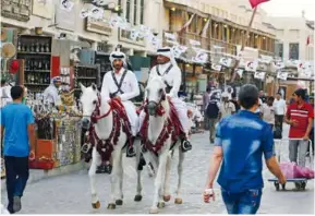  ??  ?? Le blocus imposé par l’arabie saoudite au Qatar a renforcé le nationalis­me des habitants de l’émirat, dont la figure du dirigeant est présente dans les lieux publics.