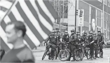  ?? ELAINE THOMPSON, AP ?? Seattle police wait to follow an anti- war march by veterans Monday. May Day, originally meant to welcome spring, changed over the years to a day of protest.