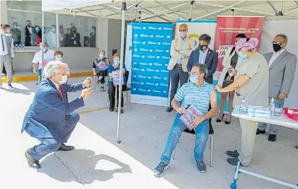  ??  ?? Presidente de la Nación. Alberto Fernández toma una foto a un vacunado, junto al gobernador Kicillof.