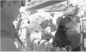  ?? NASA ?? Luca Parmitano, centre, was helped back to safety Tuesday after his helmet flooded during a spacewalk.