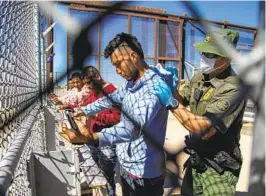  ?? ANDRES LEIGHTON AP ?? Migrants are patted down by a Border Patrol agent as they enter El Paso, Texas, from Mexico on May 10, the day before the end of Title 42 restrictio­ns.