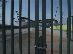  ?? JON SUPER — THE ASSOCIATED PRESS ?? Gates stand locked April 9outside the closed Manchester City Etihad Stadium in Manchester, England.