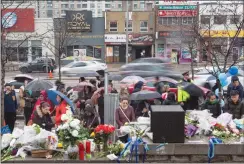  ?? CP PHOTO CHRIS YOUNG ?? People look on Wednesday at a growing memorial to the victims who died in Monday’s deadly van attack along Yonge Street in Toronto.