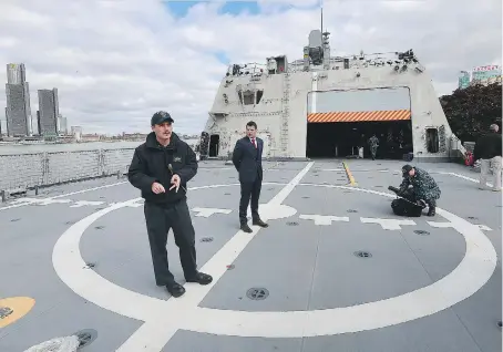  ?? DAN JANISSE ?? USS Detroit crew member David Lamberson, left, gives city officials a tour of the ship at Dieppe Park in Windsor. The latest fleet addition made U.S. naval history on Monday when it became the first American warship to make its first port of call in a...