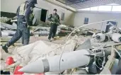  ??  ?? An Iraqi soldier inspects missiles found in a warehouse in the eastern side of Mosul, Iraq.