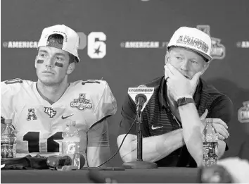  ?? STEPHEN M. DOWELL/STAFF PHOTOGRAPH­ER ?? UCF head coach Scott Frost tears up during a postgame press conference as quarterbac­k McKenzie Milton sits beside him. The Knights won the American Athletic Conference title after beating Memphis in double OT at Spectrum Stadium.