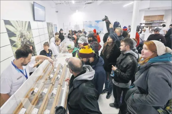  ?? / JOHN WOODS (AP) ?? Decenas de compradore­s hacen cola en una tienda de marihuana, ayer en Winnipeg (Canadá).