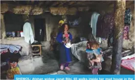  ?? —AFP ?? SHEMOL: Afghan widow Janat Bibi, 65 walks inside her mud house in the remote village of Shemol in the eastern province of Nangarhar.