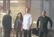  ?? Scott Garfield
Associated Press ?? THE CAST and crew had to “pick up the pieces” to finish “Furious 7” after the death of Paul Walker, second from right, according to Wan.