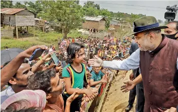  ?? — PTI ?? Union home minister Amit Shah meets people residing near Mankachar BPO (Border Out-Post) in Assam on Monday.