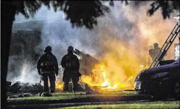  ?? THE PRESS-ENTERPRISE ?? Firefighte­rs are on the scene of a plane crash in Riverside, Calif., on Monday. The deadly crash injured several when a small plane wrecked into two homes.