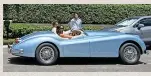  ?? ?? Sleek...the couple arrive for post-wedding brunch in their 1954 classic Jaguar gift