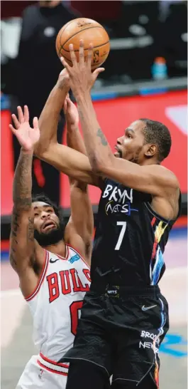  ?? SARAH STIER/GETTY IMAGES ?? Nets star Kevin Durant shoots over Bulls guard Coby White during the second half Saturday in New York. White was called for a foul on the play.