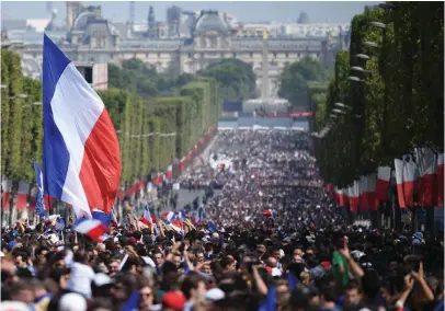  ?? FOTO: ERIC FEFERBERG / AFP / LEHTIKUVA ?? Det franska landslaget möttes av en segerfest med tusentals fans som flockat till Champs Elysées i Paris i går kväll.