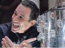  ?? GRACE HOLLARS/INDYSTAR ?? Helio Castroneve­s points to his newest likeness on the Borg-Warner Trophy.