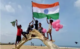  ?? — PTI ?? Boys wave a tricolour ahead of Independen­ce Day, at the Marina beach in Chennai on Sunday.