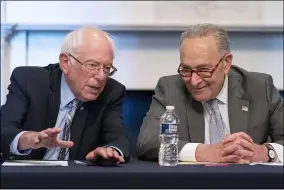  ?? JACQUELYN MARTIN — THE ASSOCIATED PRESS ?? Senate Majority Leader Chuck Schumer of N.Y., right, sits next to Sen. Bernie Sanders, I-Vt., during a meeting with Senate Democrats on the Budget Committee June 16.